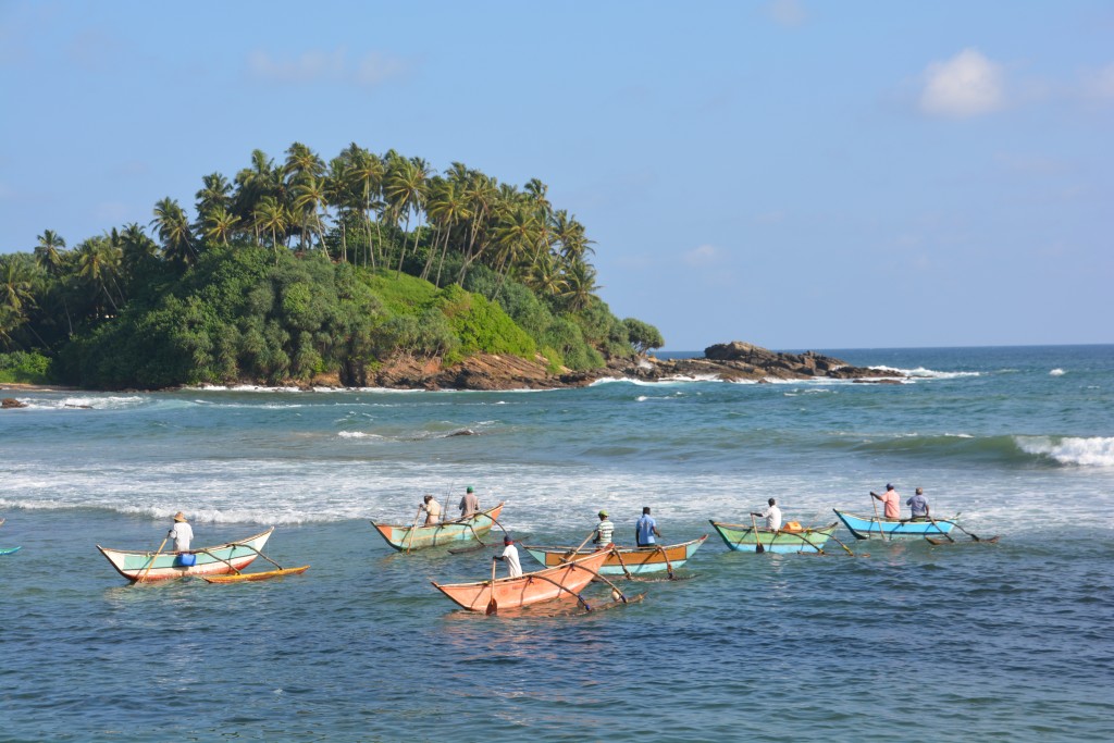 Fishermen in their narrow dug-out canoes fishing in the shallow waters off the south coast