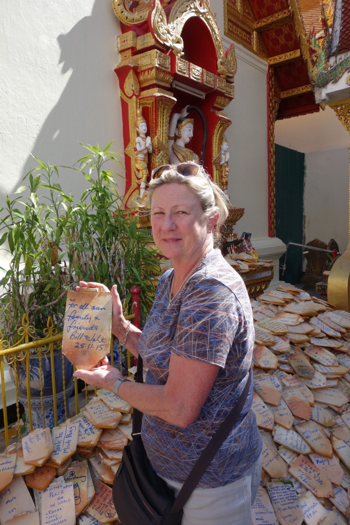 Julie writing her prayers on a roof tile to be added to a temple in the Doi Suthep complex