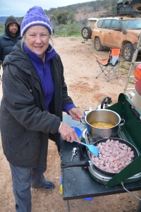 Julie preparing scrambled eggs with ham and cheese on a cold morning in Gammon Ranges