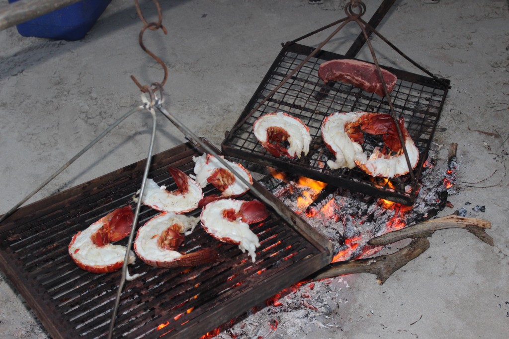 Tas cooks up fresh crayfish on the open fire in the sand