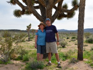 Julie and I seeking shelter under a large joshua tree in the middle of the desert