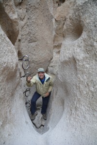 Climbing up the rings in a narrow crevasse of Banshee Canyon