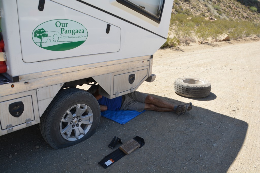 Not happy...here I am again under Tramp changing one of his tires - this time in stinking 90F heat