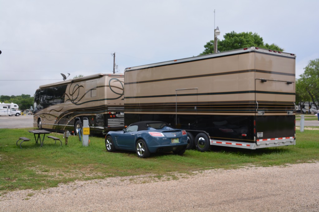 Texans love their RVs and the bigger the better. This bus-sized RV also pulls a huge toy trailer which carries this nice little sports car and probably many other essential items for these two people