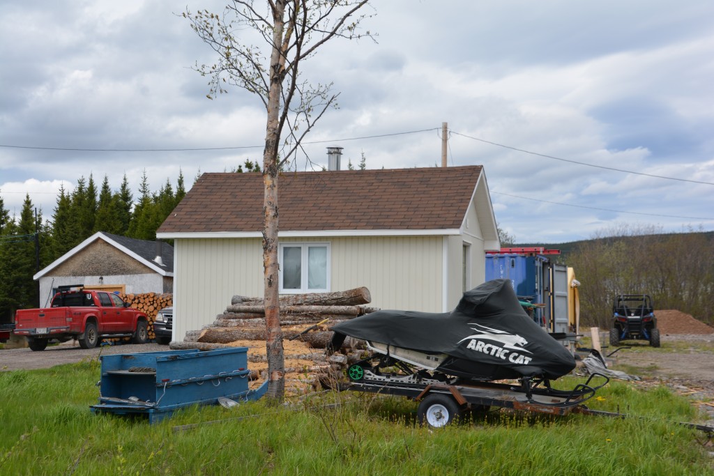 The quintessential front yard - ATV, snowmobile, sled and piles of wood. This guy's got it made!